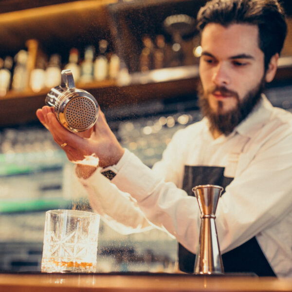 Handsome bartender making drinking and cocktails at a counter Handsome bartender making drinking and cocktails at a counter